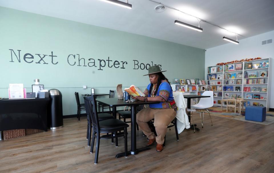 Nina Bradford owner of Longevity Vegan Cuisine takes time to read before a meeting at Next Chapter Books on East Warren Ave. Thursday, Nov 09, 2023.