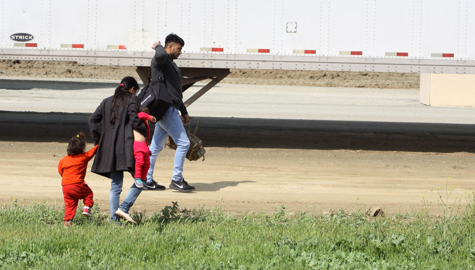 (FOTOS) La familia migrante que cruzó ilegalmente la frontera frente a los muros de Trump