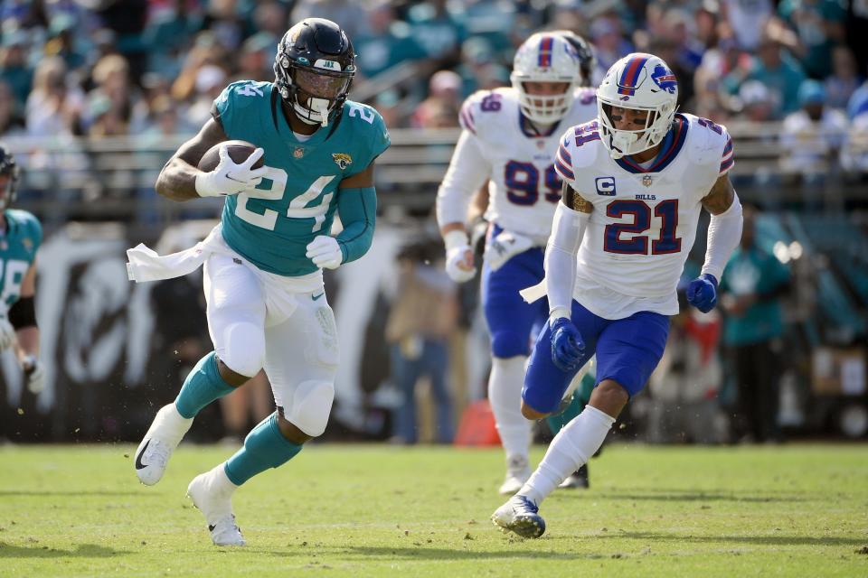 Jacksonville Jaguars running back Carlos Hyde (24) runs for yards against Buffalo Bills safety Jordan Poyer (21) during the first half of an NFL football game, Sunday, Nov. 7, 2021, in Jacksonville, Fla. (AP Photo/Phelan M. Ebenhack)