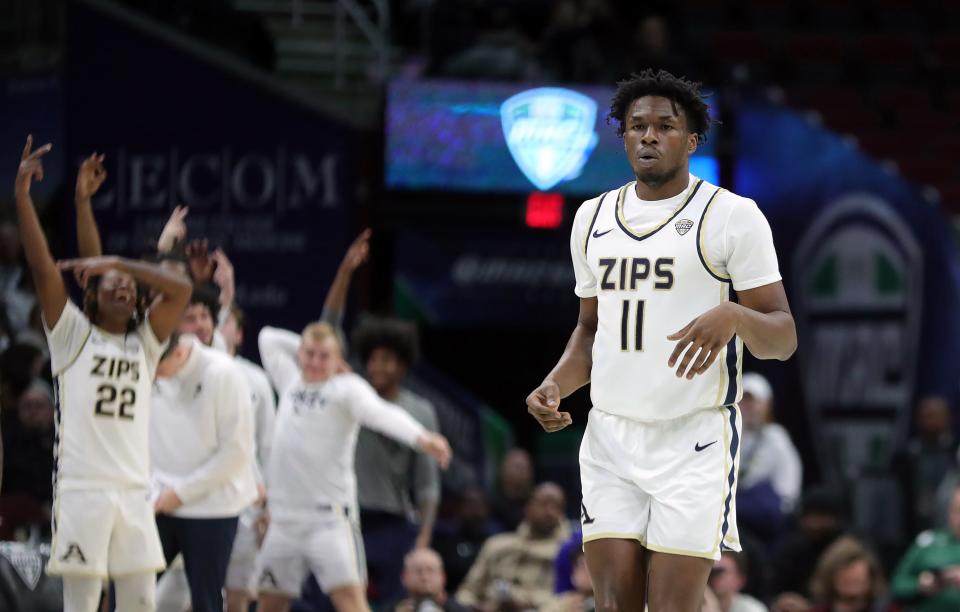 The Akron bench celebrates after Zips forward Sammy Hunter (11) makes a 3-pointer in the semifinals of the Mid-American Conference Tournament on Friday in Cleveland.