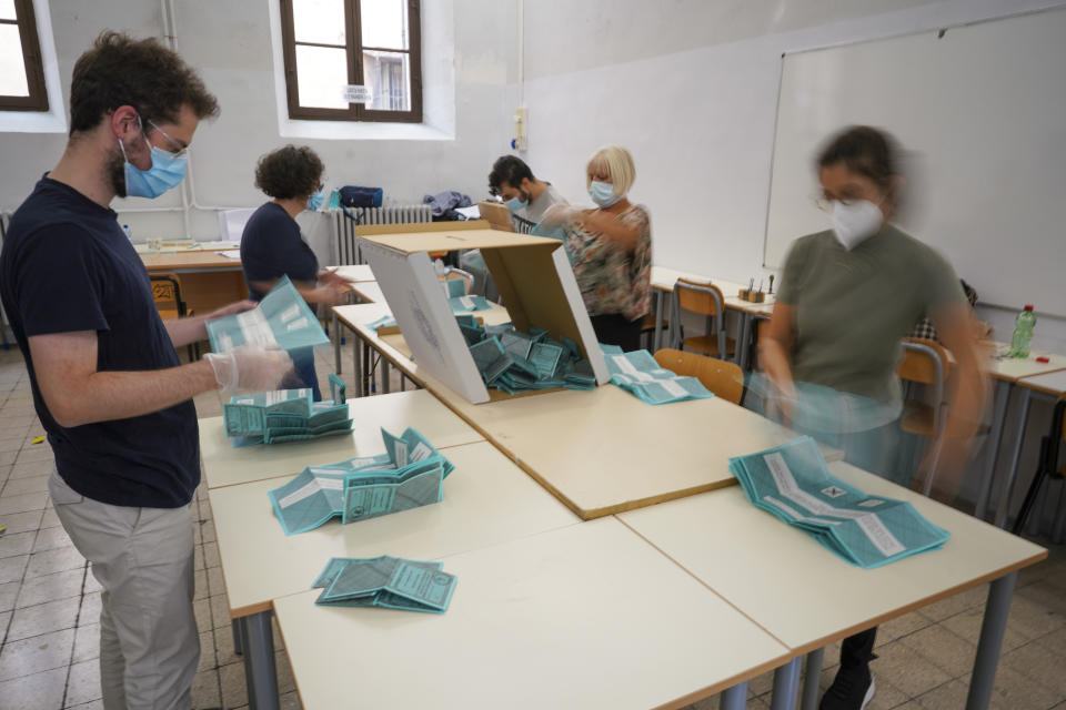 Scrutineers count ballots after the closing of a polling station, in Rome, Monday, Sept. 21, 2020. On Sunday and Monday Italians voted nationwide in a referendum to confirm a historical change to the country's constitution to drastically reduce the number of Members of Parliament from 945 to 600. Eighteen million of Italian citizens will also vote on Sunday and Monday to renew local governors in seven regions, along with mayors in approximately 1,000 cities. (AP Photo/Andrew Medichini)