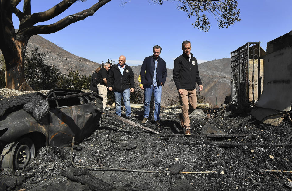 From left, L.A. City Councilman Mike Bonin, California Governor Gavin Newsom and L.A. City Mayor Eric Garcetti tour a burned home along Tigertail Road in Brentwood, Calif., Tuesday Oct. 29, 2019. (Wally Skalij/Los Angeles Times via AP, Pool)