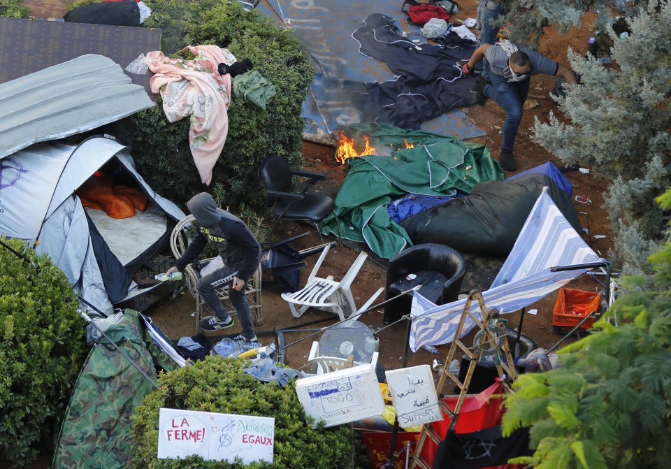 Hezbollah supporters burn tents in the protest camp set up by anti-government protesters near the government palace, in Beirut, Lebanon, Tuesday, Oct. 29, 2019. The violence came shortly after dozen others, also wielding sticks, attacked a roadblock on a main Beirut thoroughfare set up by the protesters. (AP Photo/Hussein Malla)