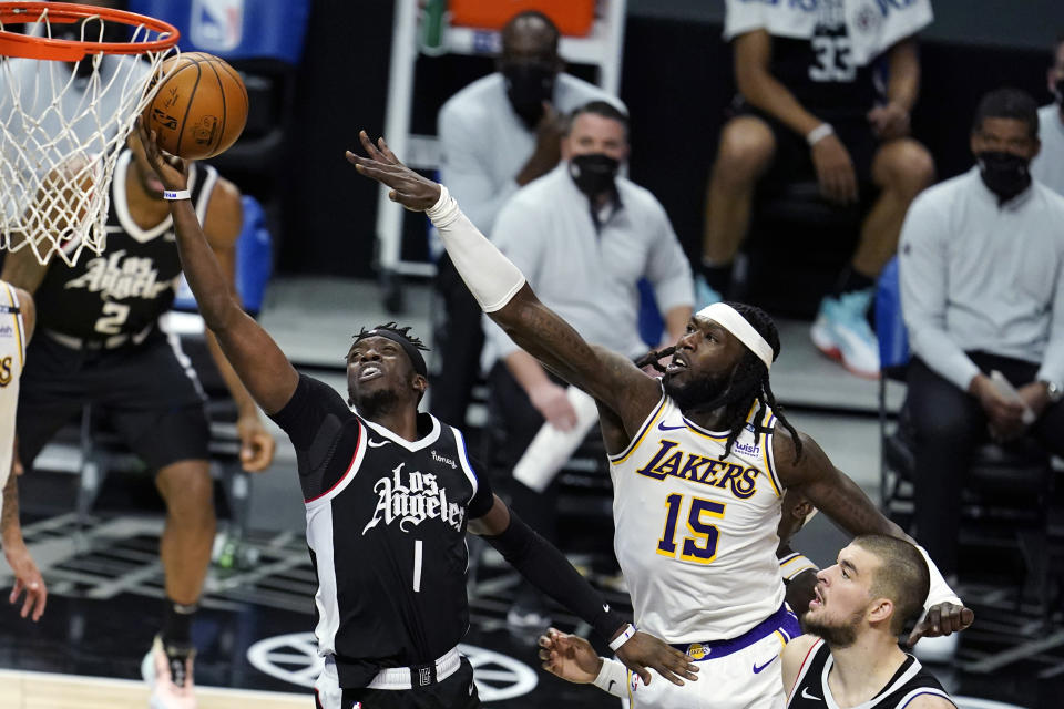 Los Angeles Clippers guard Reggie Jackson (1) drives past Los Angeles Lakers center Montrezl Harrell (15) during the first half of an NBA basketball game Sunday, April 4, 2021, in Los Angeles. (AP Photo/Marcio Jose Sanchez)