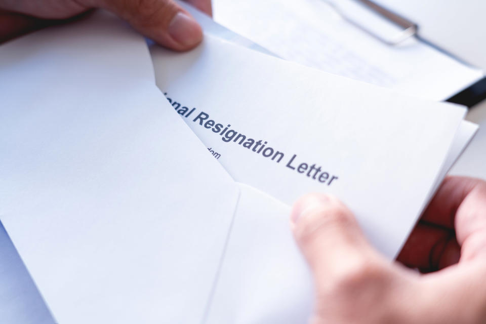 Resignation letter being taken out of an envelope by an employer