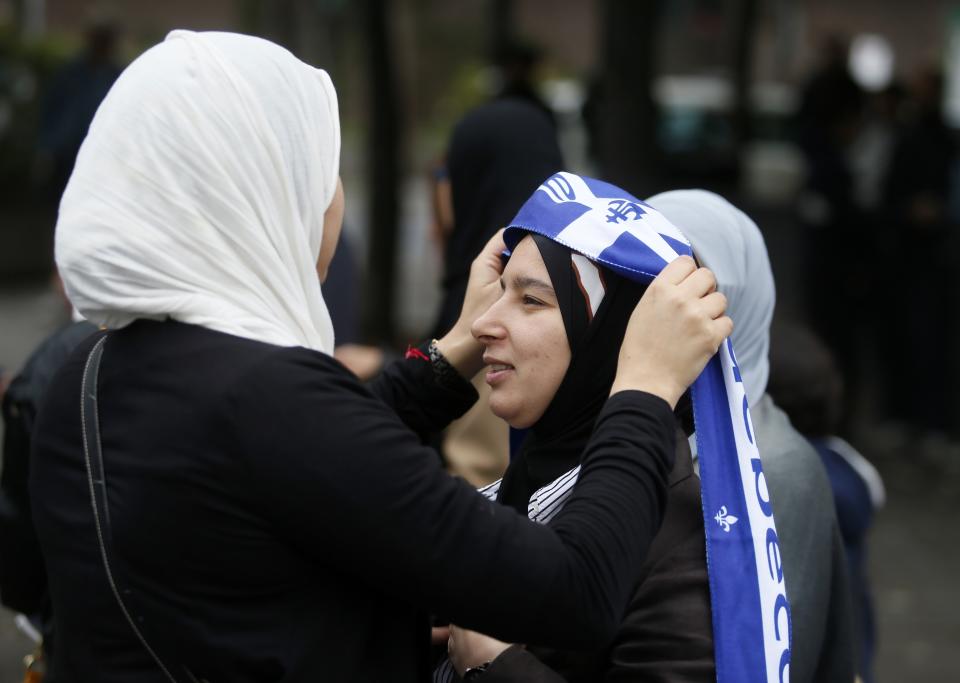 A demonstrator adds a Quebec flag to her veil during a protest against Quebec's proposed Charter of Values in Montreal