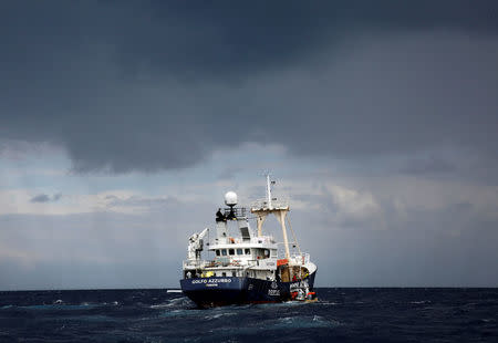 FILE PHOTO: Lifeguards transfer migrants to the former fishing vessel Golfo Azzurro during a rescue operation, as lifeguards from the Spanish NGO Proactiva Open Arms rescue all 112 on aboard, including two pregnant women and five children, as it drifts out of control in the central Mediterranean Sea, some 36 nautical miles off the Libyan coast January 2, 2017. REUTERS/Yannis Behrakis/File Photo