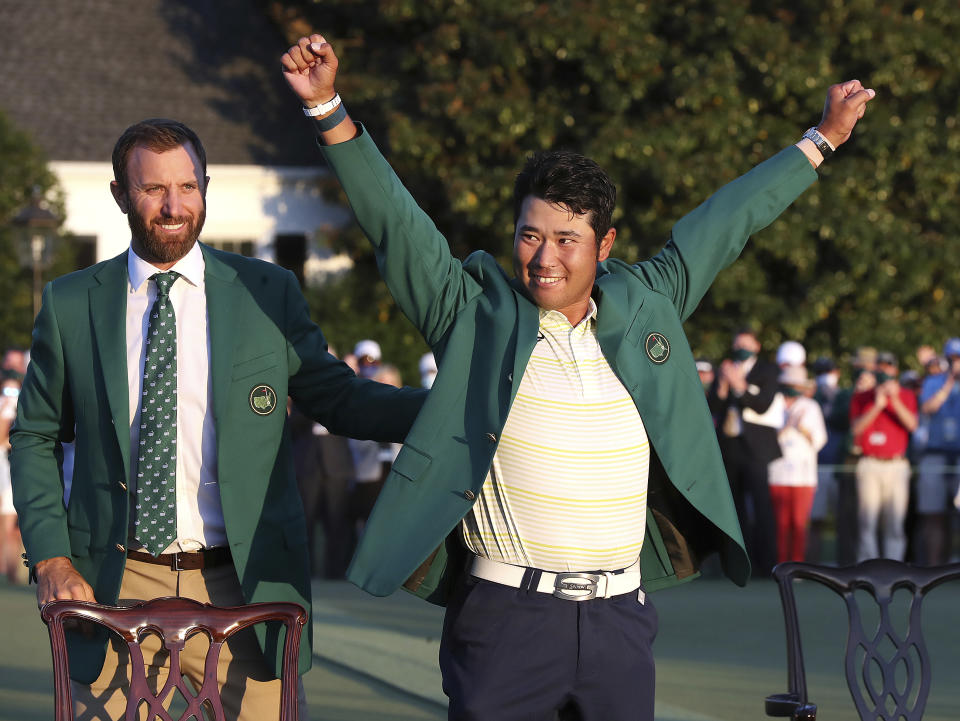 Hideki Matsuyama, of Japan, celebrates while wearing the champion's green jacket as Dustin Johnson looks on after winning the Masters golf tournament on Sunday, April 11, 2021, in Augusta, Ga. (Curtis Compton/Atlanta Journal-Constitution via AP)