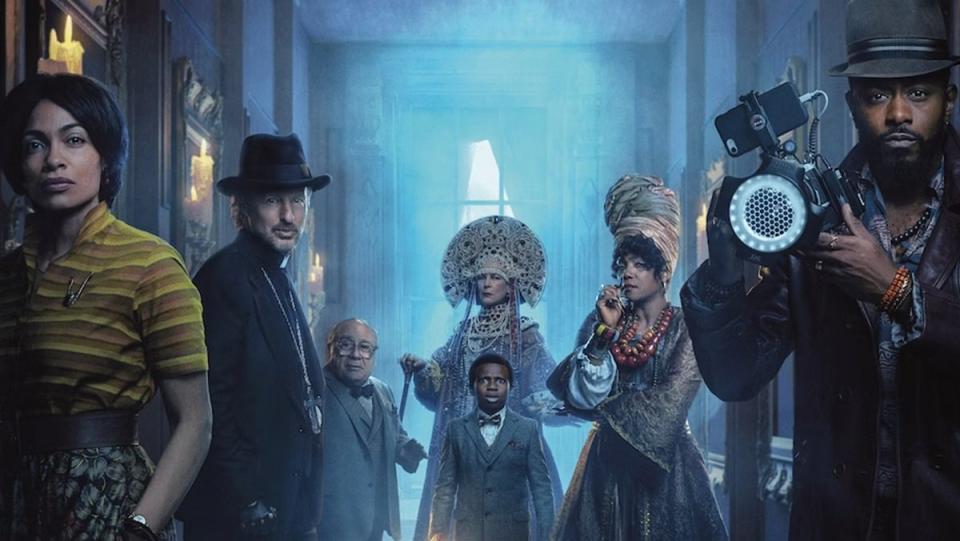 Haunted Mansion poster showcases, from left, Rosario Dawson, Owen Wilson, Danny DeVito, Jamie Lee Curtis, Chase Dillon, Tiffany Haddish, and LaKeith Stanfield, in the hallway of the spooky home.