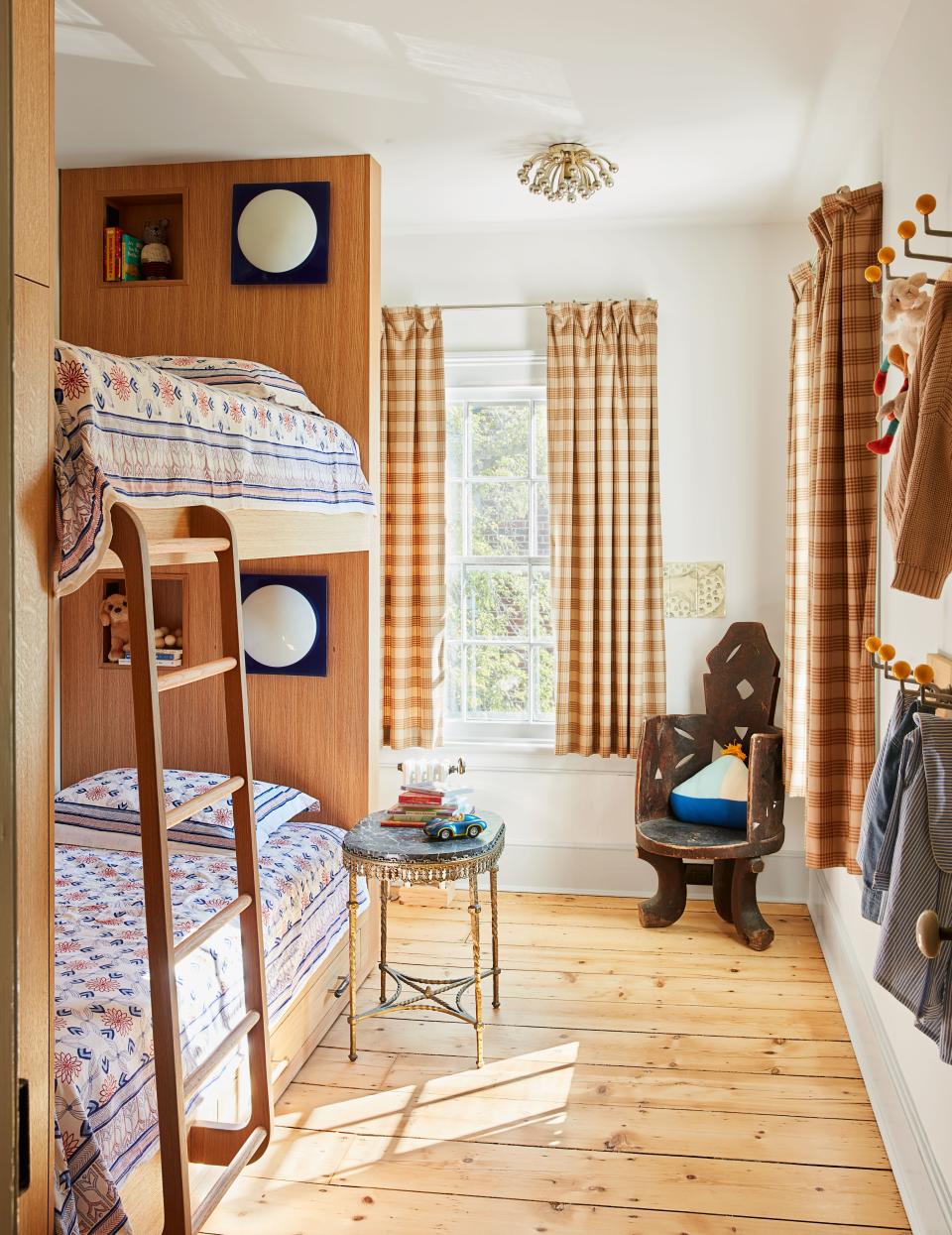 In Bash’s room, vintage sconces accent built-in bunk beds; curtains of Holland & Sherry fabric.