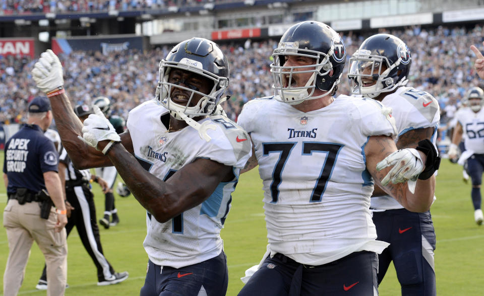 Tennessee Titans wide receiver Corey Davis (84) celebrates with offensive tackle Taylor Lewan (77) after Davis caught the winning touchdown pass against the Philadelphia Eagles in overtime of an NFL football game Sunday, Sept. 30, 2018, in Nashville, Tenn. The Titans won 26-23. (AP Photo/Mark Zaleski)