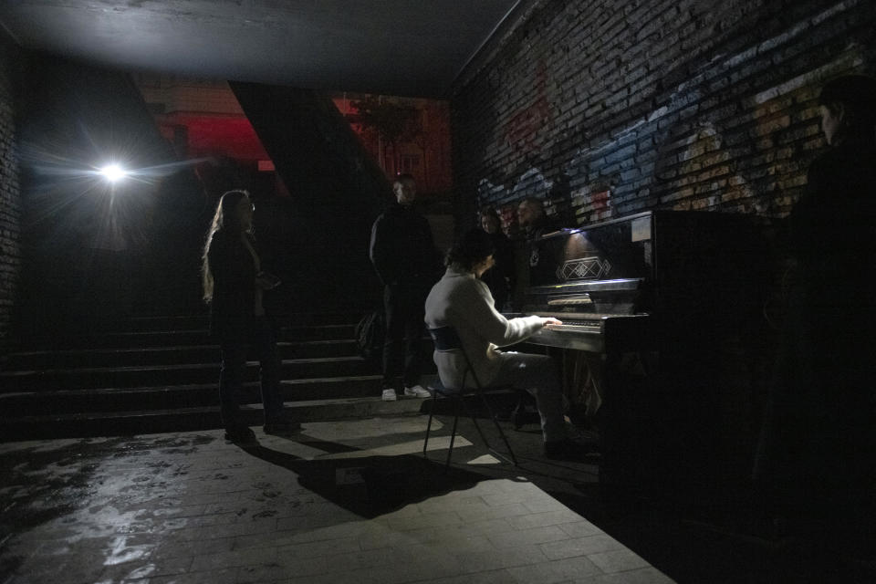 FILE - A person plays a piano in a street underpass during a blackout in Kyiv, Ukraine, Nov. 6, 2022. The hard realities of Ukraine’s capital are that a once comfortably livable city of 3 million people is now becoming a tough place to live. But Kyiv has hope, resilience and defiance in abundance. And perhaps more so now than at any time since Russia invaded Ukraine nine months ago. (AP Photo/Andrew Kravchenko, File)