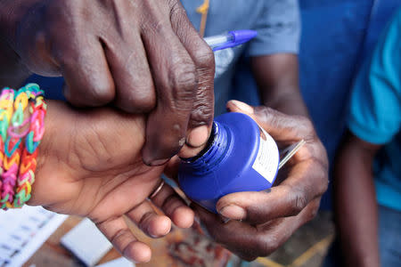 A poll worker marks the thumb of a voter with ink at a polling station in the National School of Damassins, Haiti, November 20, 2016. REUTERS/Andres Martinez Casares