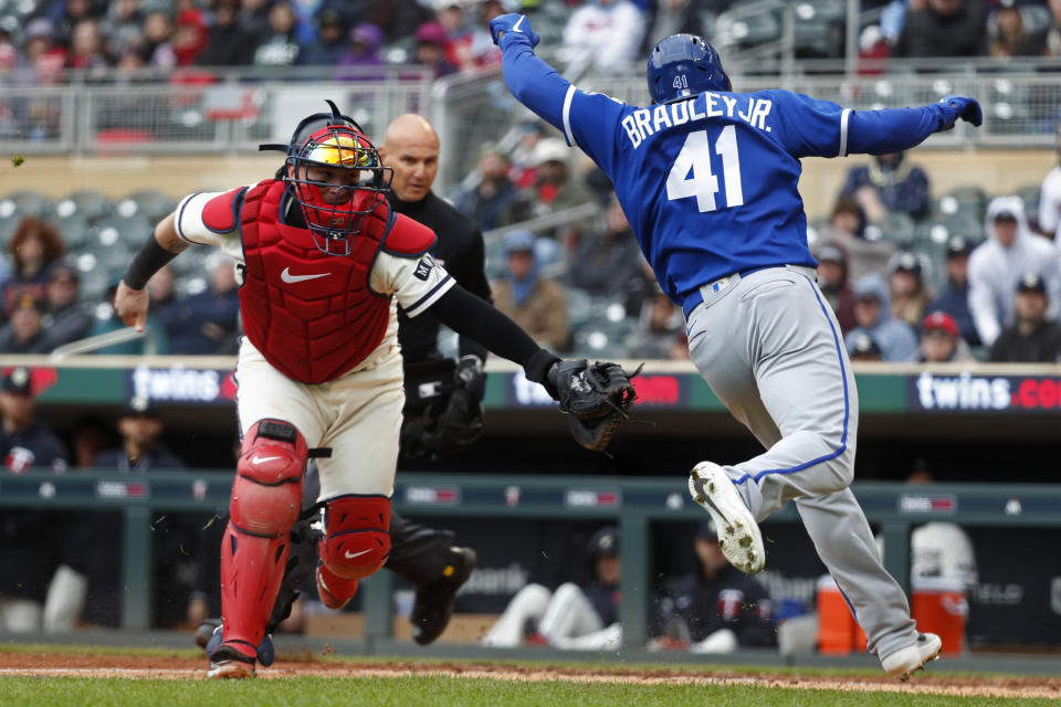 Kansas City Royals' Jackie Bradley Jr. (41) avoids Minnesota Twins catcher Christian Vazquez, left, to score on an error on a ball hit by Matt Duffy in the sixth inning of a baseball game Sunday, April 30, 2023, in Minneapolis. (AP Photo/Bruce Kluckhohn)