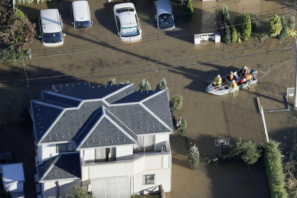 Rescuers on a boat make their way through flooded residential area hit by Typhoon Hagibis, in Sakado, on the outskirts of Tokyo, Sunday, Oct. 13, 2019. Rescue efforts for people stranded in flooded areas are in full force after a powerful typhoon dashed heavy rainfall and winds through a widespread area of Japan, including Tokyo.(Kyodo News via AP)