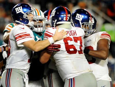 Dec 14, 2015; Miami Gardens, FL, USA; New York Giants quarterback Eli Manning (left) tries to break up a fight involving teammate Justin Pugh at Sun Life Stadium. Mandatory Credit: Robert Duyos-USA TODAY Sports