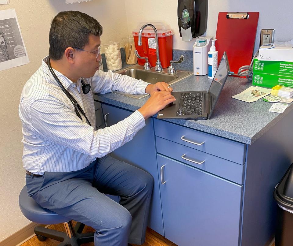 Even while Dr. Daniel Shen, seen here, is conducting a telemedicine visit at the Perry Klasseen Family Medical Clinic in Oklahoma City, he always goes to a private exam room — as if the patient were there in person — and shuts the door for privacy.  [Photo by Pam Olson]