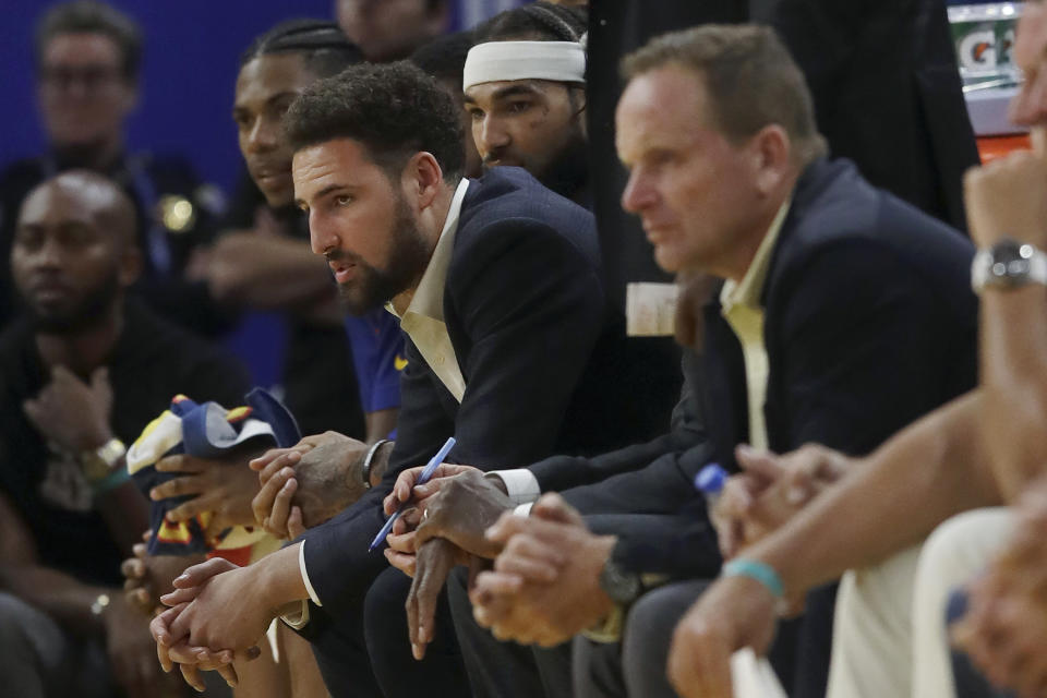 Injured Golden State Warriors guard Klay Thompson, center left, watches from the bench during the second half of an NBA basketball game against the Portland Trail Blazers in San Francisco, Monday, Nov. 4, 2019. (AP Photo/Jeff Chiu)