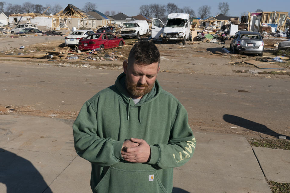 Ben Cerimovic, an immigrant from Bosnia, pauses while working to help clean up in a neighborhood devastated by the recent tornado Tuesday, Dec. 14, 2021, in Bowling Green, Ky. There's a close-knit, thriving Bosnian community in Bowling Green, which has a robust refugee resettlement program to bring migrants to Western Kentucky. Cerimovic volunteered here Saturday and Sunday, then he had to take Monday off to gather his emotions. (AP Photo/James Kenney)