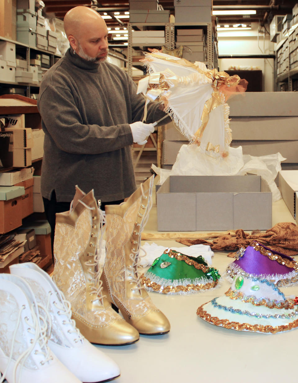 In this Jan. 7, 2013, photo, Wayne Phillips, the Louisiana State Museum’s curator of costumes and textiles, shows a baby doll costume in the museum’s warehouse in New Orleans. On Jan. 19, 2013, the museum opened an exhibit about the history and modern rebirth of baby-doll masking, groups of African-American women dressed in skimpy or short, ruffled dresses on Mardi Gras. (AP Photo/Janet McConnaughey)