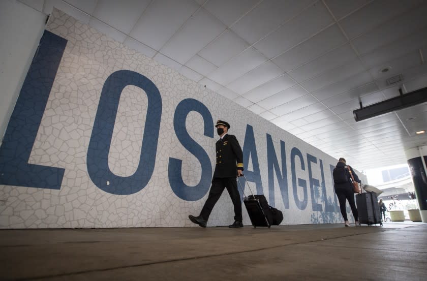 LOS ANGELES, CA - NOVEMBER 23: Travelers make their way at LAX as the Thanksgiving holiday getaway period gets underway on Monday, Nov. 23, 2020 in Los Angeles, CA. Millions of Americans are carrying on with their travel plans ahead of Thanksgiving weekend despite the CDC's urgent warnings to stay home as the number of daily cases and hospitalizations in the country continue to hit record highs. Confirmed cases in the U.S. for the disease topped 12 million on Saturday as more than 193,000 new infections were recorded in the US on Friday. This broke the previous record for the largest single-day spike on Thursday - and over 82,000 patients are now hospitalized across the country. (Allen J. Schaben / Los Angeles Times)