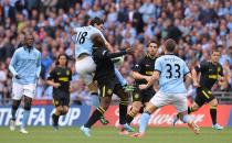 Wigan Athletic's Arouna Kone (centre) and Manchester City's Gareth Barry battle for the ball