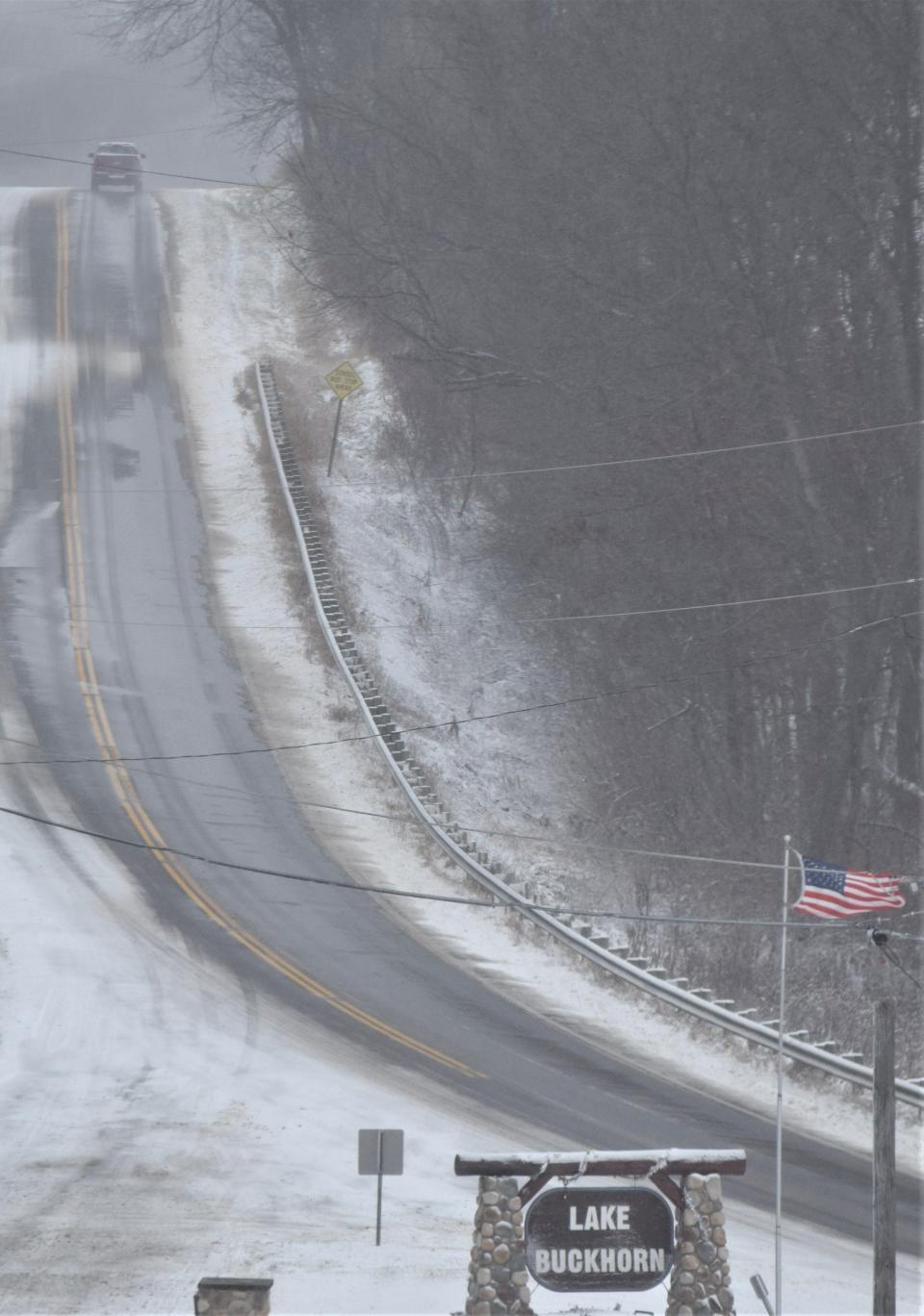 Wind gusts of better than 30 mph whipped the flag at the entrance to Lake Buckhorn as a lone vehicle makes its way along state Route 83 south of Millersburg.
