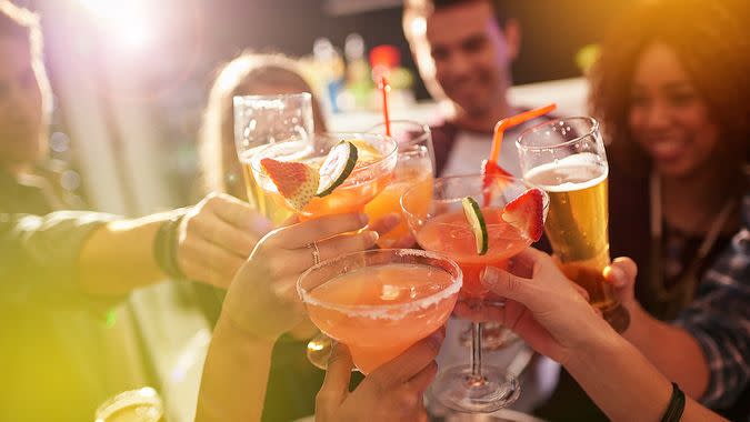 Shot of a group of people toasting with their drinks at a nightclub.