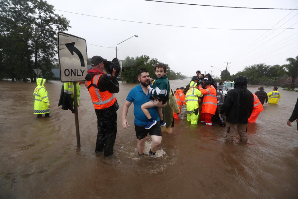 Residents of Lismore wade through dangerous floodwaters on Monday.