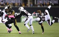 Hamilton Tiger-Cats' Terrell Sinkfield (L) runs the ball past Ottawa Redblacks' Brandyn Thompson (C) and Damaso Munoz during the second half of their CFL football game in Hamilton, in this October 17, 2014 file photo. REUTERS/Mark Blinch/Files (CANADA - Tags: SPORT FOOTBALL TPX IMAGES OF THE DAY)