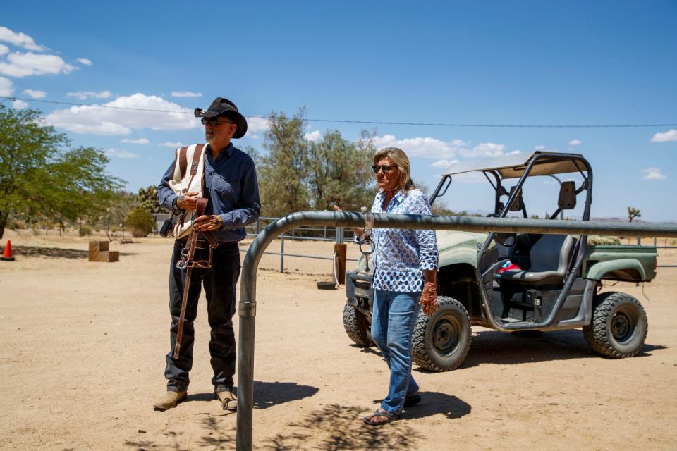 Jeff Eamer, left, and Joey's Home Animal Rescue owner Melinda Allen chat about the young donkey, Waylon, at the ranch in Yucca Valley, Calif., on June 29, 2022. 