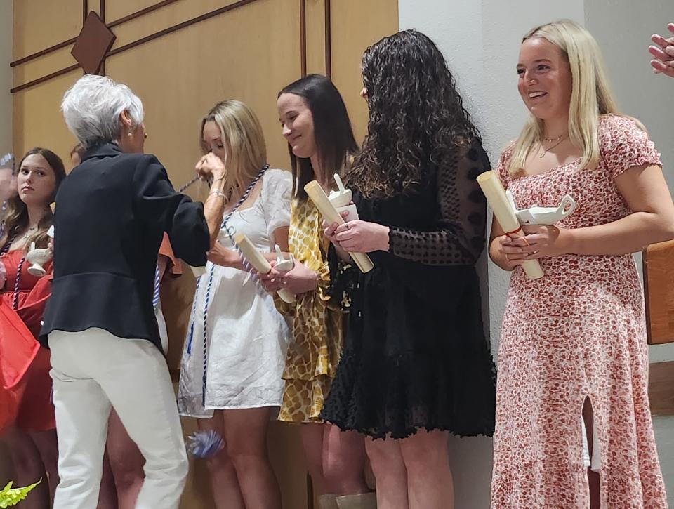 Valerie Kiper, DNP, R.N., regional dean of the Texas Tech University Health Sciences Center (TTUHSC) School of Nursing in Amarillo, dons BSN graduates with ALS cords, an item the students chose to wear in their upcoming graduation honoring Kiper, during the ceremonial lamp lighting Thursday.