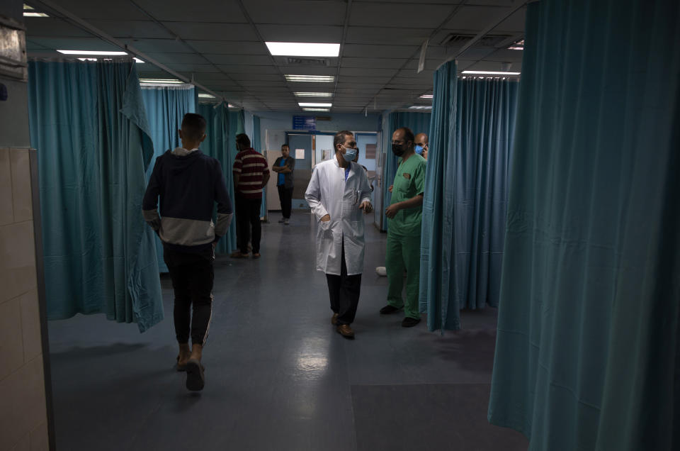 Palestinian doctors and medics walk inside the emergency room of the Shifa hospital in Gaza City, Thursday, May 13, 2021. Just weeks ago, the Gaza Strip’s feeble health care system was struggling with a runaway surge of coronavirus cases. Now doctors across the crowded coastal enclave are trying to keep up with a very different crisis: blast and shrapnel wounds, cuts and amputations. (AP Photo/Khalil Hamra)