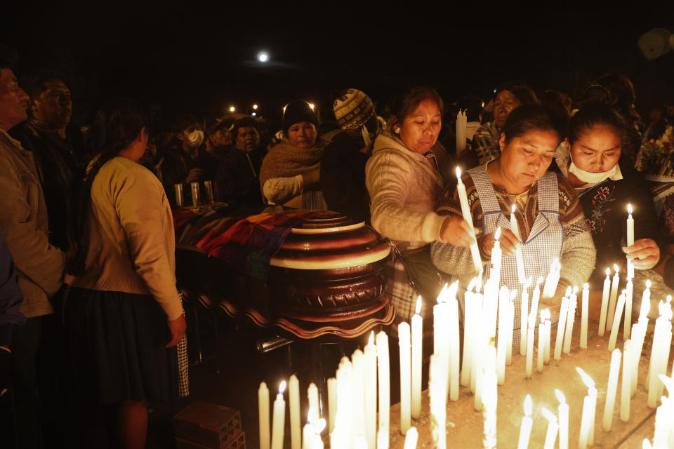 Mourners light candles around coffins of backers of former President Evo Morales that died during clashes with security forces in Sacaba, Bolivia, Friday, Nov. 15, 2019. Bolivian security forces clashed with Morales' backers leaving at least five people dead, dozens more injured and escalating the challenge to the country's interim government to restore stability. (AP Photo/Juan Karita)