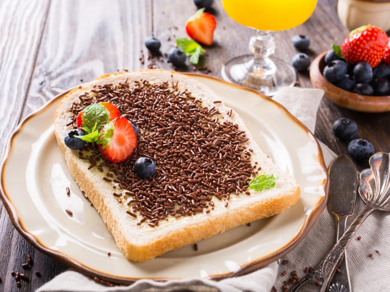 Dutch breakfast, slice of bread with hagelslag chocolate sprinkles and berries.