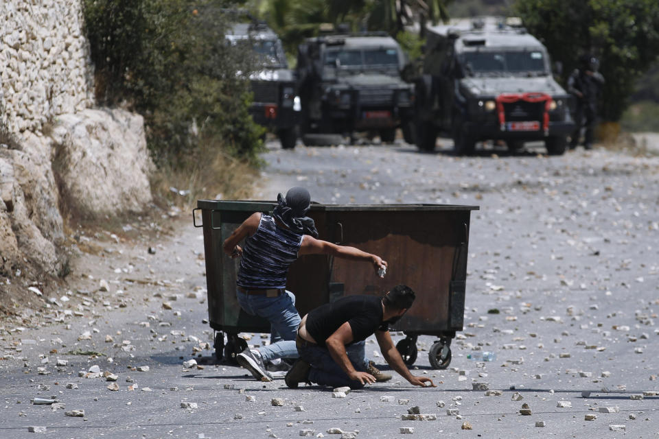 Palestinians clash with Israeli security forces following the funeral of Mohammed al-Alami, 12, in the village of Beit Ummar, near the West Bank city of Hebron, Thursday, July 29, 2021. Villagers say the boy was fatally shot by Israeli troops while traveling with his father in a car. The Israeli military has launched an investigation into the shooting. (AP Photo/Majdi Mohammed)