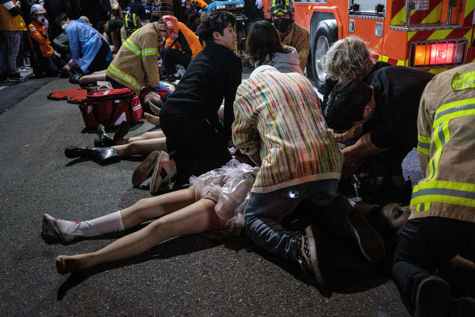 Emergency workers and others assist people who were caught in a Halloween stampede in the district of Itaewon in Seoul, on Oct. 29. More than 150 people were killed in the stampede.<span class="copyright">Albert Retief—AFP/Getty Images</span>