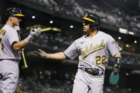 Oakland Athletics' Ramon Laureano (22) celebrates his run scored against the Arizona Diamondbacks with Athletics' Matt Chapman, left, during the fifth inning of a baseball game Monday, April 12, 2021, in Phoenix. (AP Photo/Ross D. Franklin)