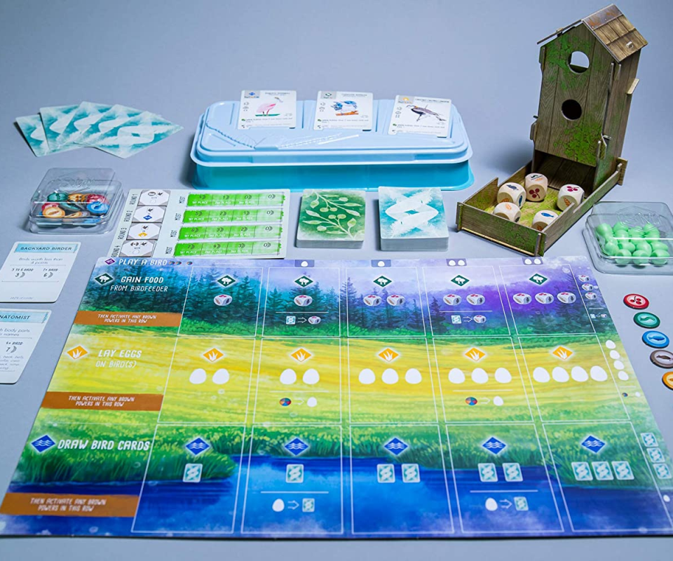 Image of boardgame laying flat with the cards and game pieces assembled on the side.