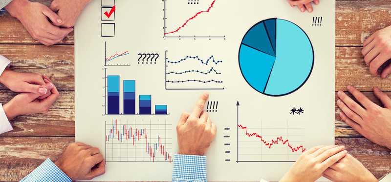 A group of people sketching and analyzing charts and data.