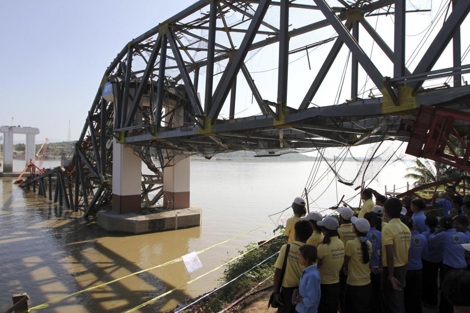People look at the Yadanatheinga bridge that has collapsed into water in Irrawaddy river after it was damaged by a strong earthquake, Monday, Nov. 12, 2012, in Kyaukmyaung township in Shwebo, Sagaing Division, northwest of Mandalay, Myanmar. A strong earthquake collapsed the bridge Sunday and damaged ancient Buddhist pagodas in northern Myanmar, and piecemeal reports from the underdeveloped mining region said mines collapsed and as many as 12 people were feared dead. Myanmar's Vice President Sai Mauk Hkam visited the damaged sites Monday, while authorities resumed their search for four missing workers near the collapsed bridge that was under construction. (AP Photo/Khin Maung Win)