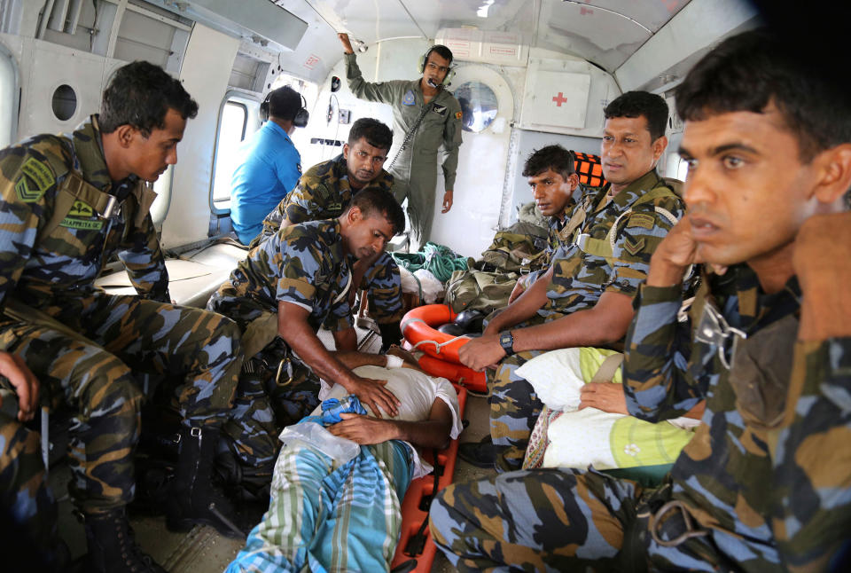 <p>Sri Lankan air force personnel attend to a flood victim inside a helicopter after rescuing him in Kalawana, in Ratnapura district of Sri Lanka, May 27, 2017. (AP Photo/Rukmal Gamage) </p>