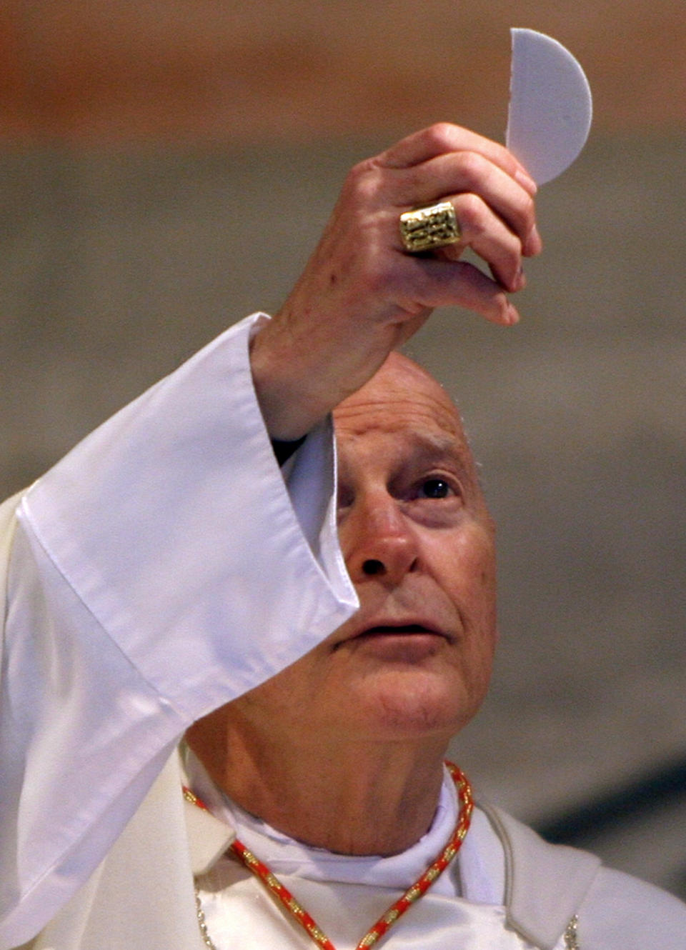 FILE - In this April 14, 2005 file photo, Washington, D.C. Cardinal Theodore McCarrick elevates the holy host during a Mass in St. Nereus and Achilleus Church in Rome. On Tuesday, Nov. 10, 2020, the Vatican is taking the extraordinary step of publishing its two-year investigation into the disgraced ex-Cardinal McCarrick, who was defrocked in 2019 after the Vatican determined that years of rumors that he was a sexual predator were true. (AP Photo/ Alessandra Tarantino, File)