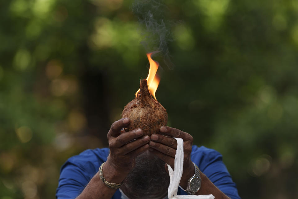 A Indian man prays with lit coconut as an offering outside a temple during the Hindu festival of lights, Diwali, in Kuala Lumpur, Malaysia, Thursday, Nov. 4, 2021. Millions of people across Asia are celebrating the Hindu festival of Diwali, which symbolizes new beginnings and the triumph of good over evil and light over darkness. Millions of people across Asia are celebrating the Hindu festival of Diwali, which symbolizes new beginnings and the triumph of good over evil and light over darkness. The festival is celebrated mainly in India but Hindus across the world, particularly in other parts of Asia, also gather with family members and friends to socialize, visit temples and decorate houses with small oil lamps made from clay. (AP Photo/Vincent Thian)
