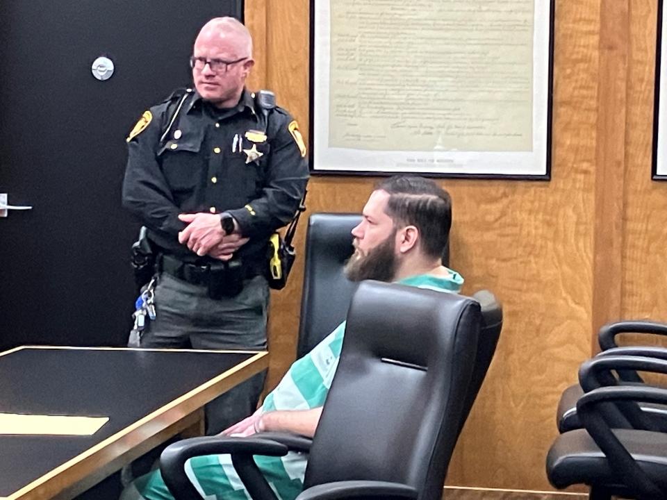 Andrew Chambers sits at the defense table before his change-of-plea hearing Wednesday afternoon in Richland County Common Pleas Court. Standing is Sgt. Keith Krupa, a court security officer.