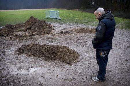 A man stands close to the grave of Omar Abdel Hamid El-Hussein at the Muslim cemetery in Broendby in this February 20, 2015 file photo. REUTERS/Nils Meilvang/Scanpix Denmark