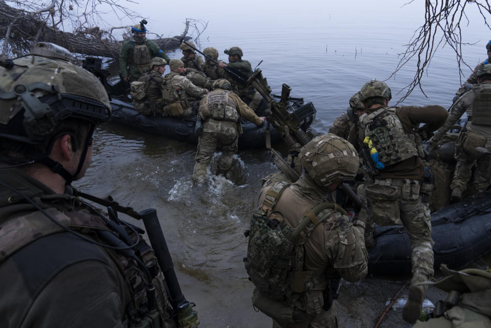 FILE - Ukrainian servicemen board a boat on the shore of Dnipro river at the frontline near Kherson, Ukraine, Sunday Oct. 15, 2023. A gloomy mood hangs over Ukraine’s soldiers nearly two years after Russia invaded their country. Ukrainian soldiers remain fiercely determined to win, despite a disappointing counteroffensive this summer and signs of wavering financial support from allies. (AP Photo/Mstyslav Chernov, File)