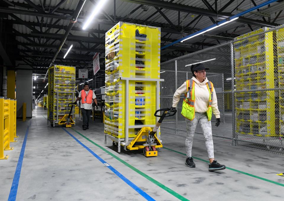 Cody Rivas and Marianela Lorts move pods of goods inside the new Amazon Fulfillment Center on Thursday, October 13, 2022, in Sioux Falls.