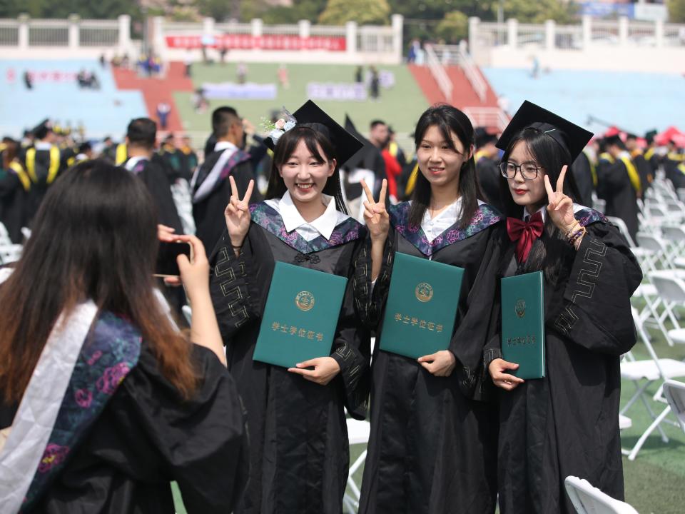 Graduates pose with their diplomas during Qingdao University of Science & Technology's Commencement Ceremony in June 2023.