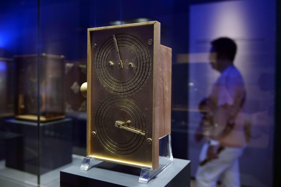 A visitor walks past a reconstruction of the Antikythera mechanism at the National Archaeological Museum in Athens.